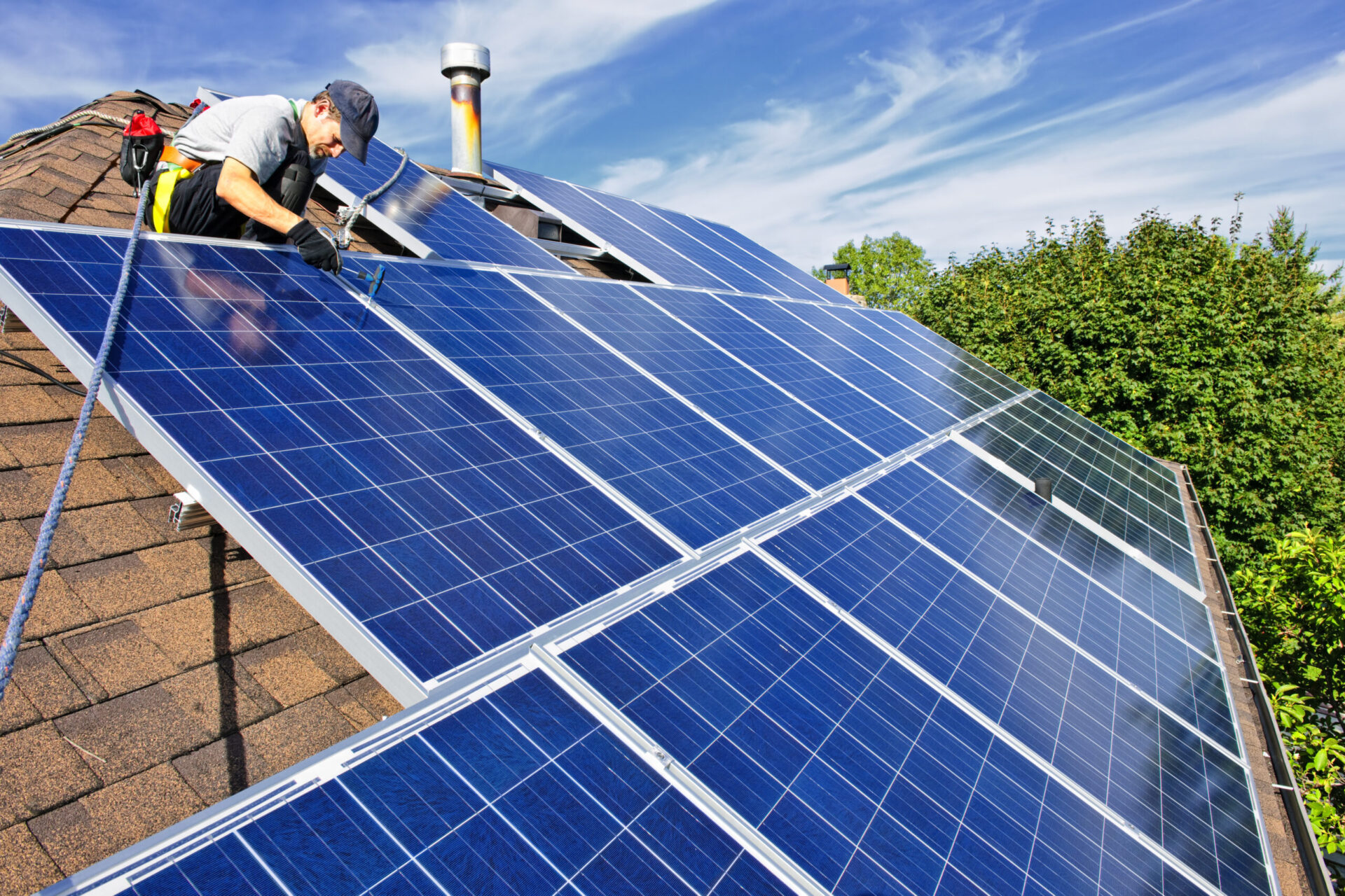 workers installing solar panel on a roof