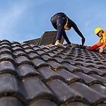 two roof worker repairing a roof